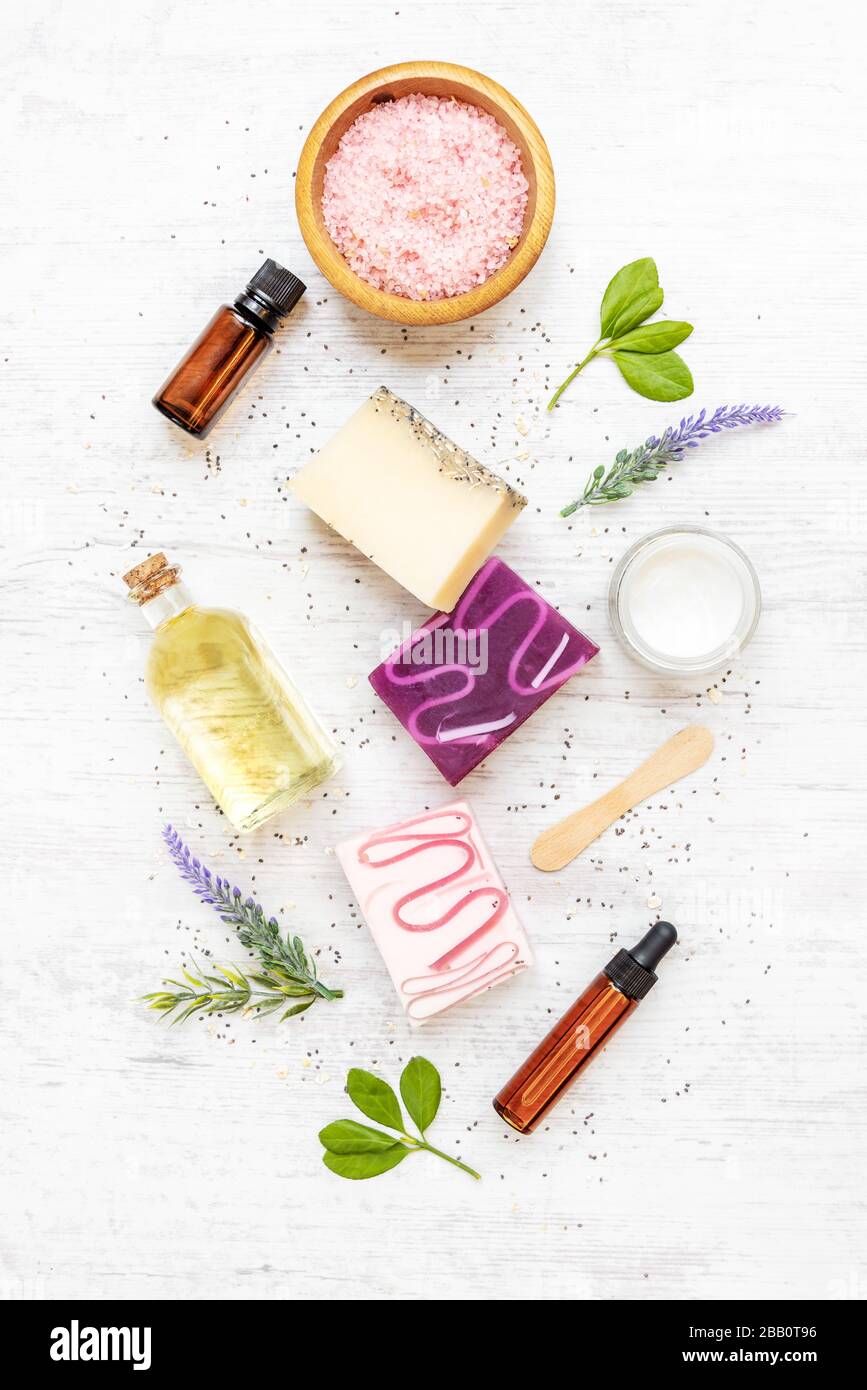 Draufsicht auf organische Seifen und Kosmetik mit Lavendel, Kräutern, chia und ätherischen Ölen. Weißer rusrischer Hintergrund. Stockfoto