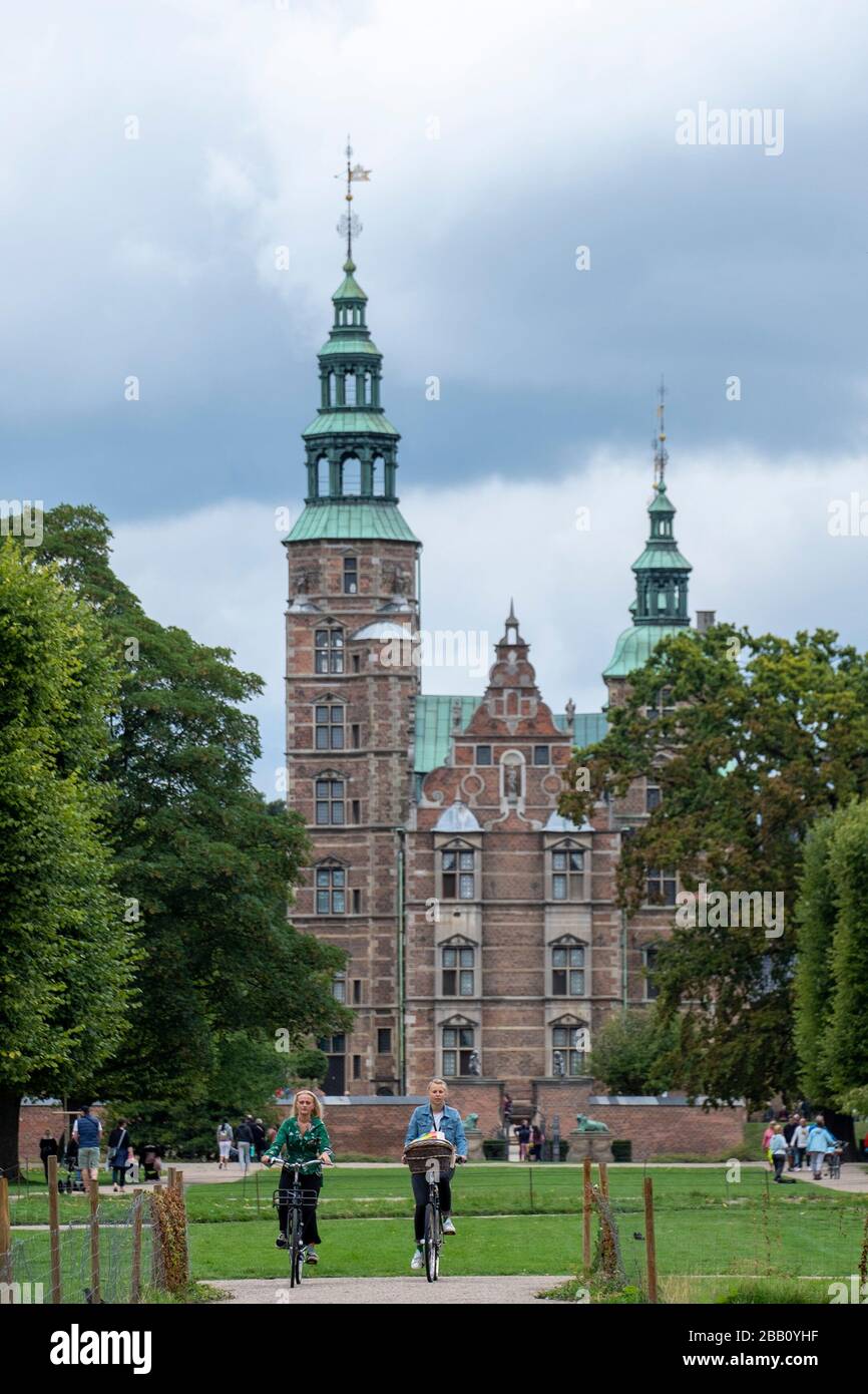 Zwei Radfahrer fahren mit dem Fahrrad vor dem Schloss Rosenborg in Kopenhagen, Dänemark, Europa Stockfoto