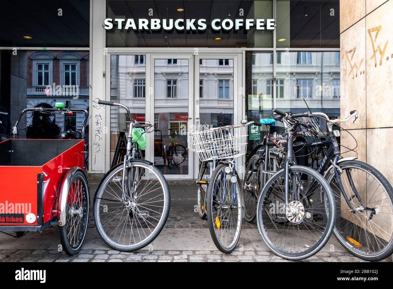 Fahrräder, die vor einem Starbucks Coffee Store in Kopenhagen, Dänemark, Europa geparkt wurden Stockfoto