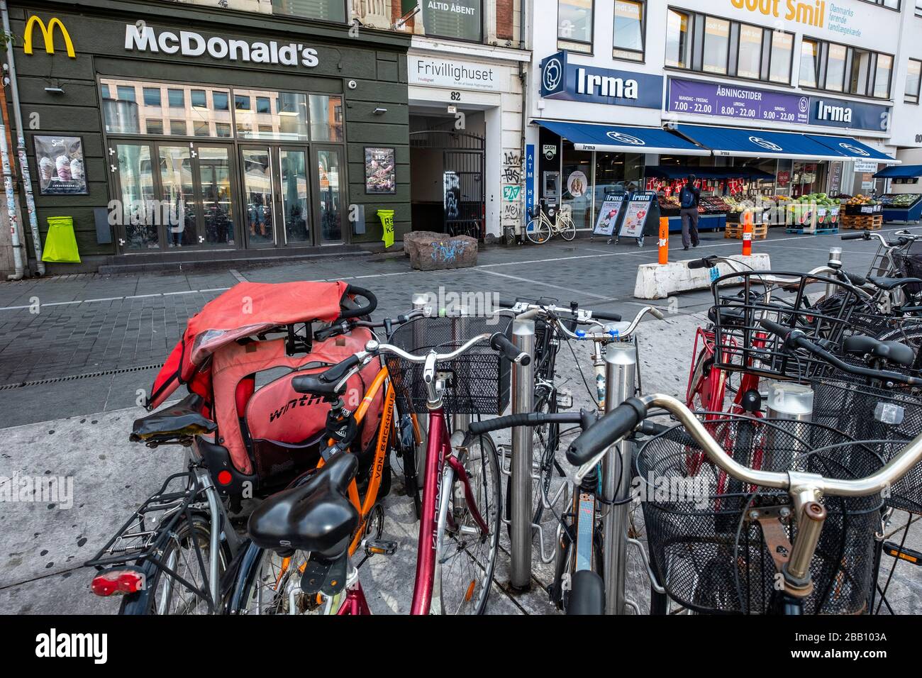 Fahrräder, die vor einem McDonald's Fast-Food-Restaurant und einem Irma Supermarkt in Kopenhagen, Dänemark, Europa geparkt wurden Stockfoto