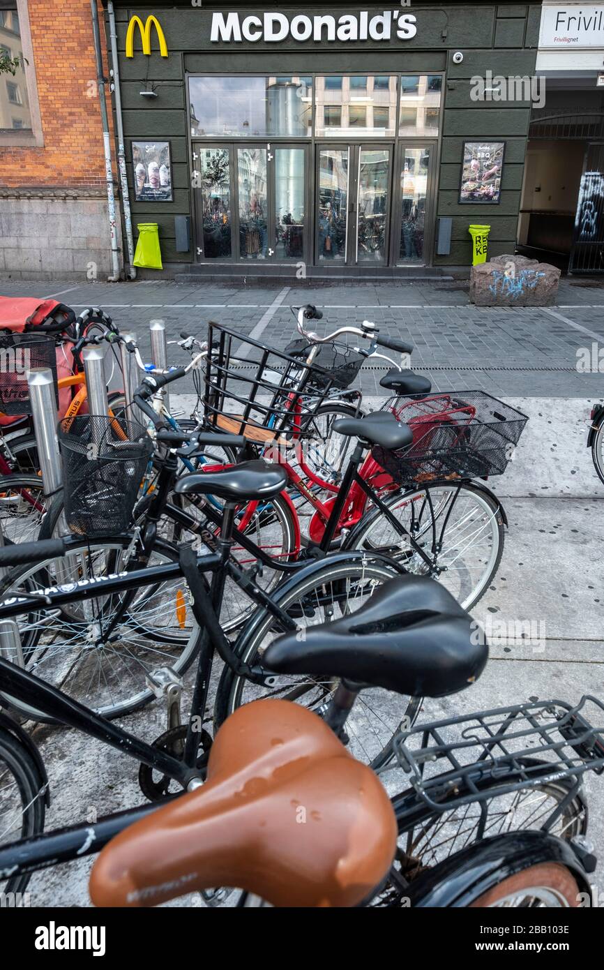 Fahrräder, die vor einem McDonald's Fast-Food-Restaurant in Kopenhagen, Dänemark, Europa geparkt wurden Stockfoto