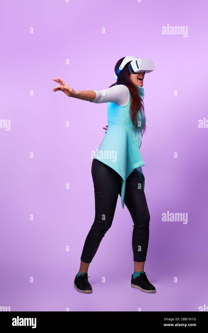 Frau mit Virtual reality Headset. Konzept der virtuellen Realität, Spiele, Unterhaltung und Kommunikation. Bild in der modernen Neon farbe Gamma. Stockfoto