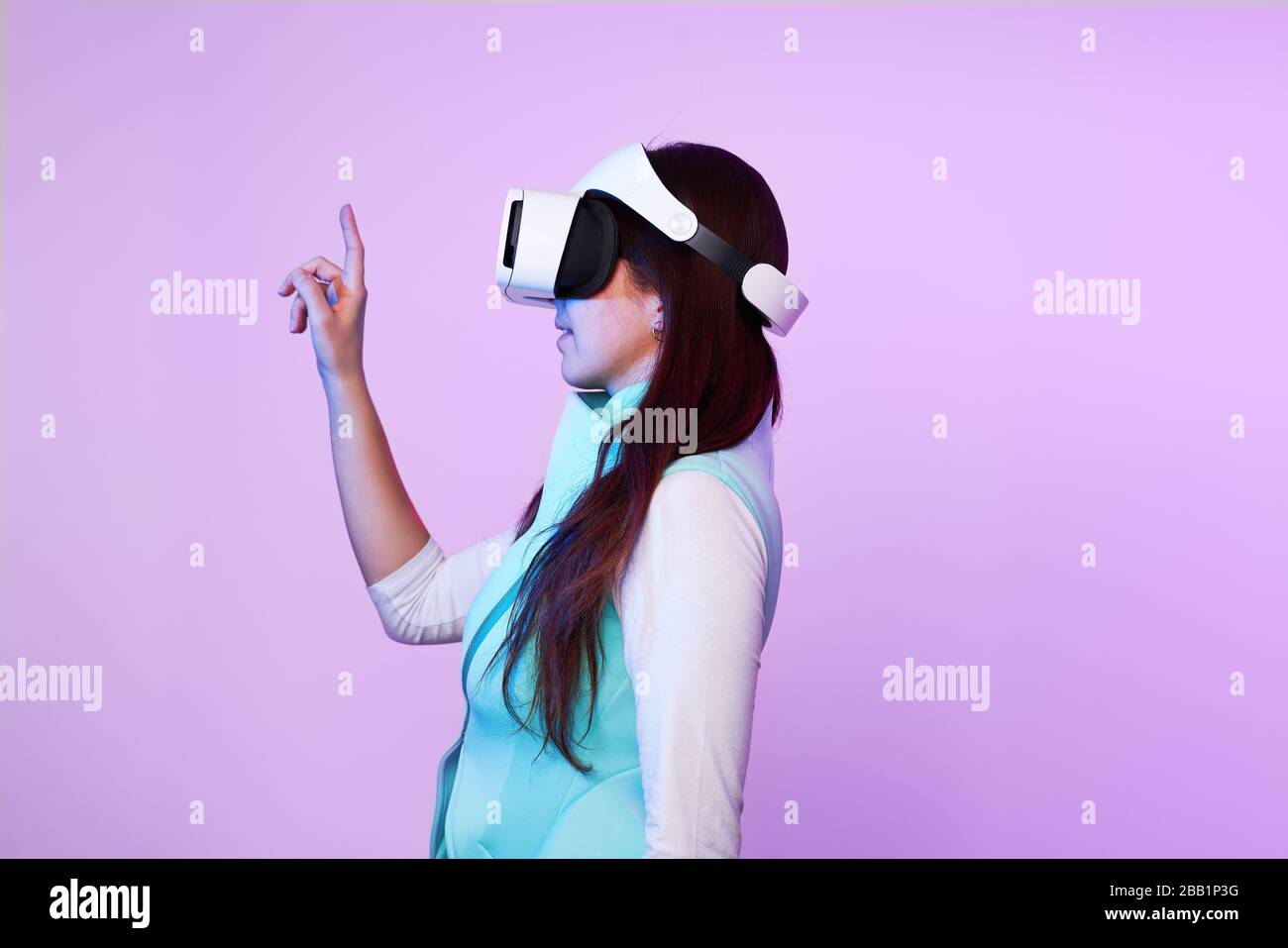 Frau mit Virtual reality Headset. Konzept der virtuellen Realität, Spiele, Unterhaltung und Kommunikation. Bild in der modernen Neon farbe Gamma. Stockfoto