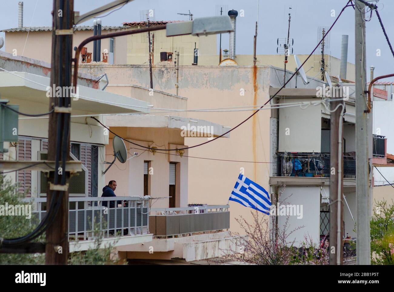 ALEXANDROUPOLI, GRIECHENLAND - 24. März 2020 - EIN Mann auf sitzt auf einem Wohnbalkon in Alexandroupoli, Griechenland, nachdem die griechische Regierung eine strikte Sperre verhängt hatte Stockfoto