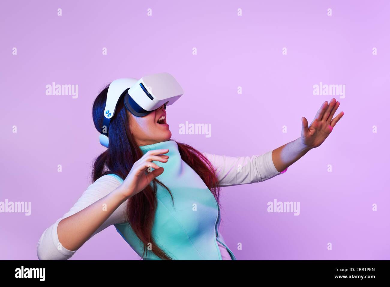 Frau mit Virtual reality Headset. Konzept der virtuellen Realität, Spiele, Unterhaltung und Kommunikation. Bild in der modernen Neon farbe Gamma. Stockfoto