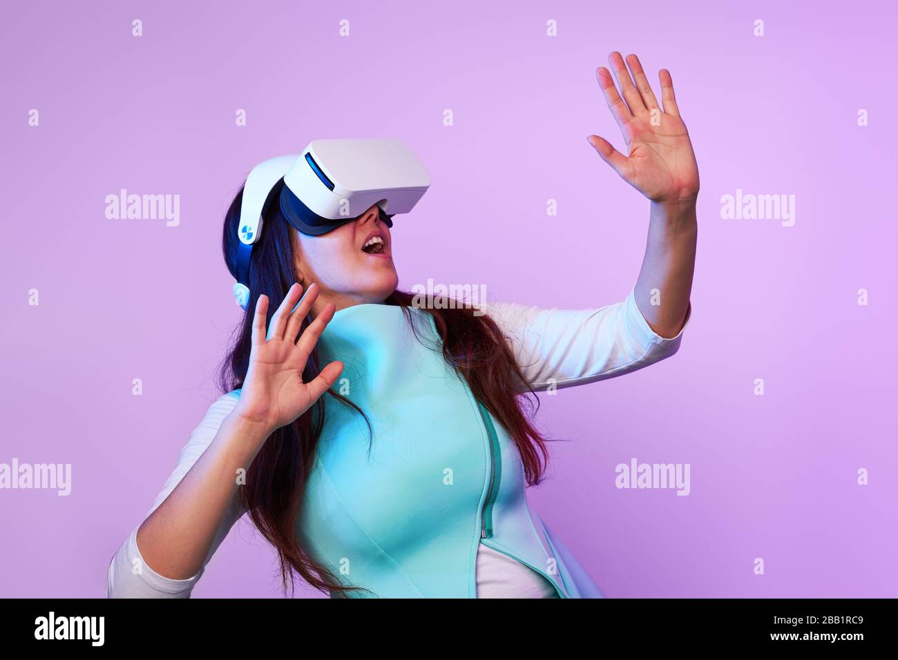 Frau mit Virtual reality Headset. Konzept der virtuellen Realität, Spiele, Unterhaltung und Kommunikation. Bild in der modernen Neon farbe Gamma. Stockfoto