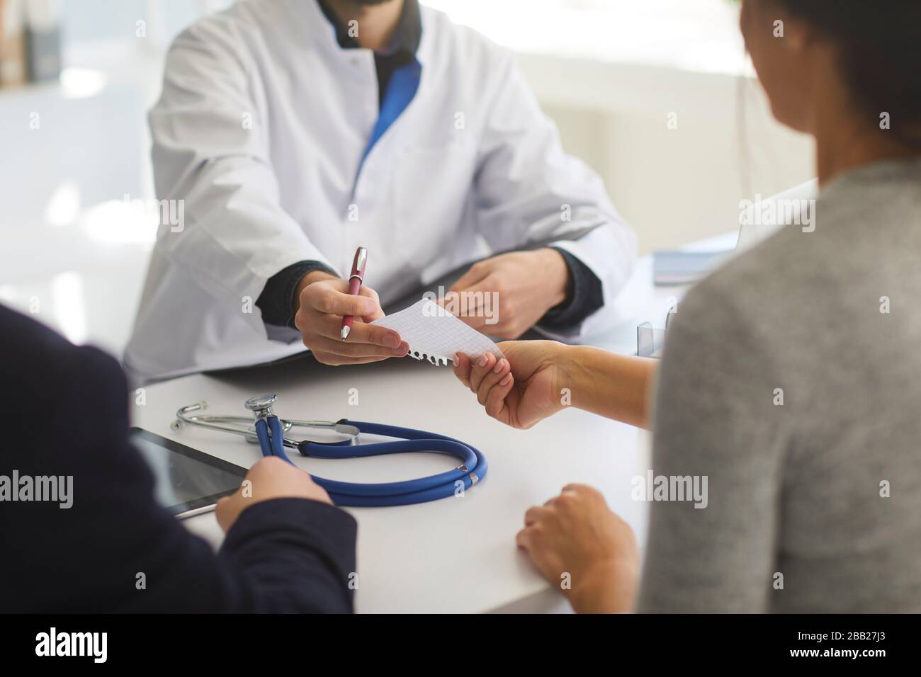 Selbstbewusster Arzt verschreibt Patienten in der Klinik. Stockfoto