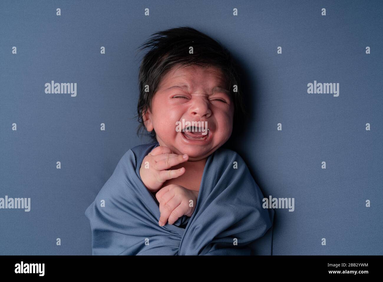 Neugeborenes weinendes Baby. Neugeborenes Kind müde und hungrig, nachdem es posiert hat Stockfoto