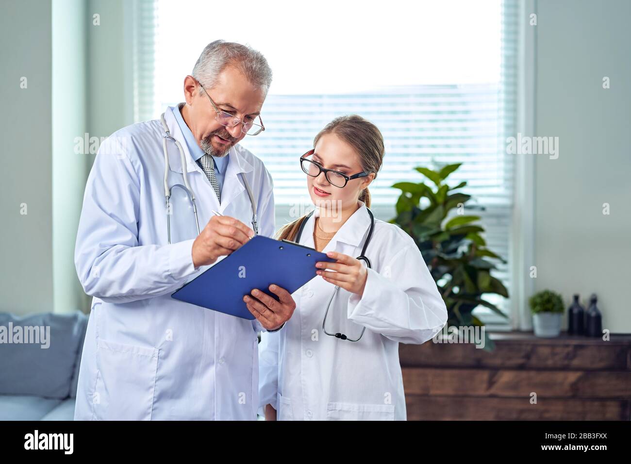Das Medical Doctor Team diskutiert über Konferenz zur gemeinsamen Untersuchung des Patient Medical Report im Untersuchungsraum. Ärzte Stockfoto
