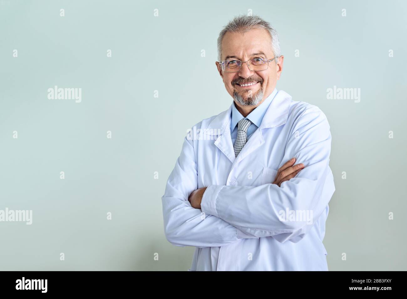 Fröhliche reife Arzt posing und lächelnd an Kamera, Gesundheitswesen und Medizin. Stockfoto