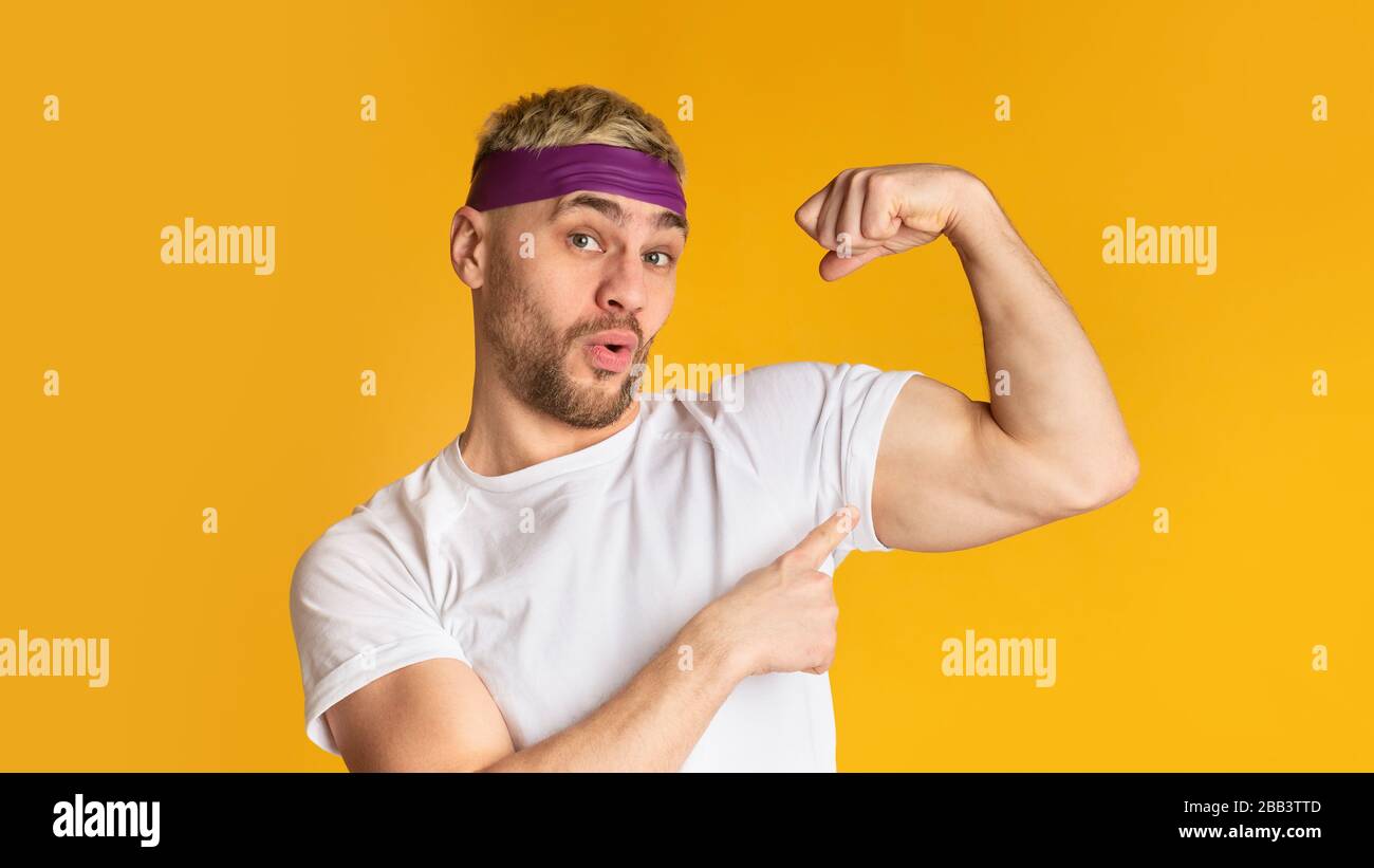 Konzept der Sportergebnisse. Lustiger Mann zeigt Bizeps Stockfotografie