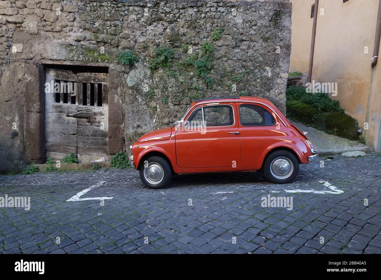 Kleines altes rotes italienisches Auto in der uralten städtischen Straße Stockfoto