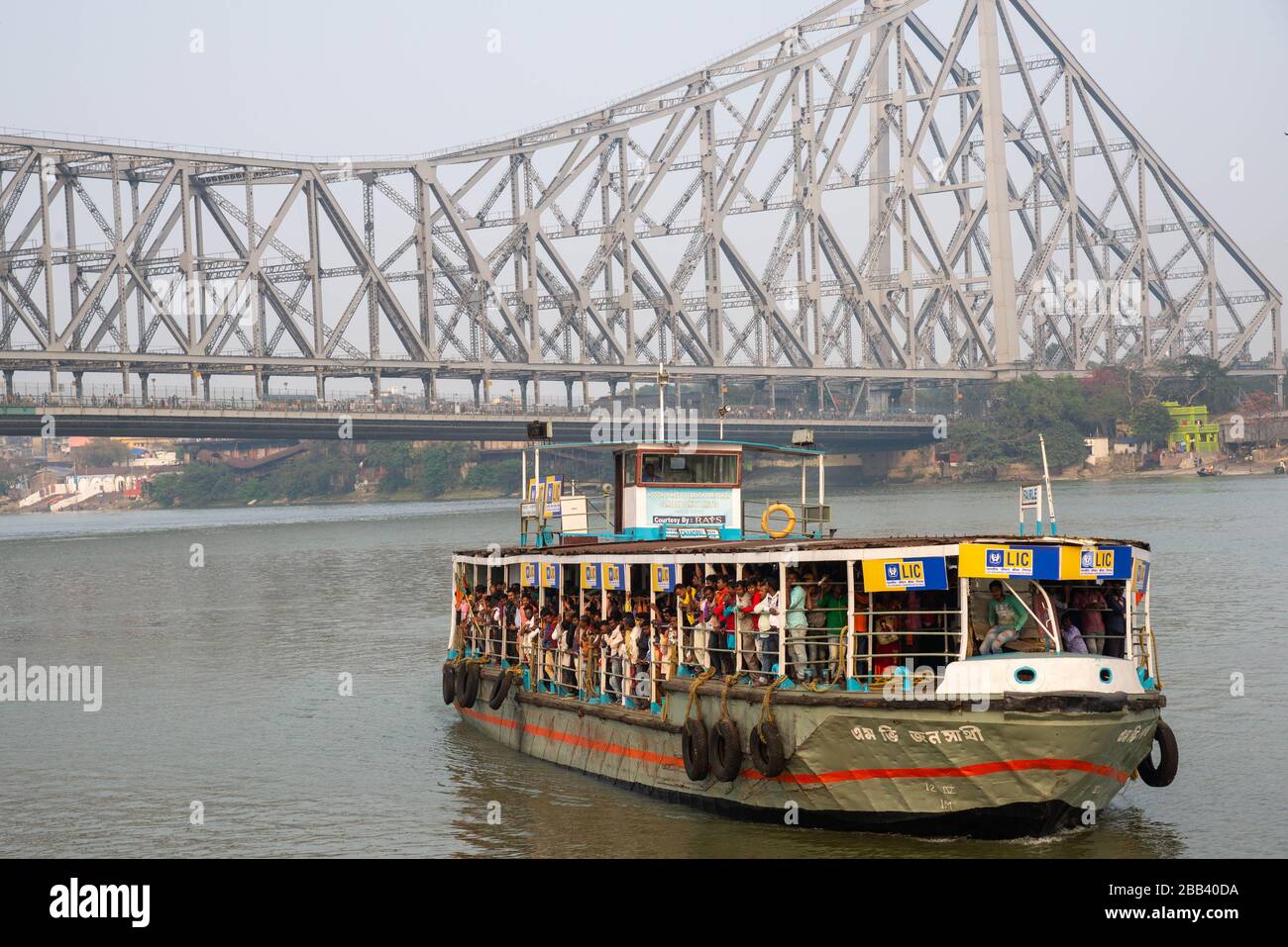 Blick auf die Howrah Brücke mit der Fähre am Hooghly River in Kalkutta, Indien Stockfoto