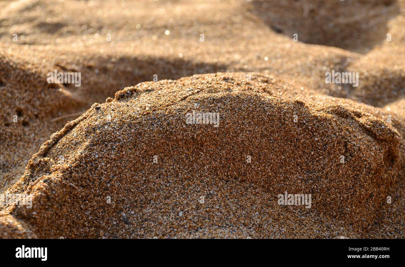 Schöner Nahblick auf den ockerfarbenen Sand am Roten Strand in Matala, Insel Kretas, Griechenland. Stockfoto