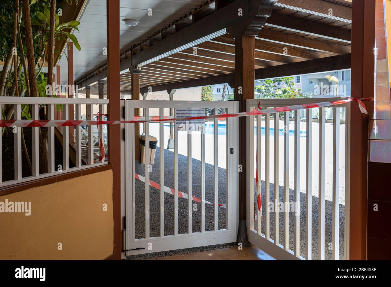 Zugang zum Gemeinschaftspoolbereich eines Apartmentblocks, der während des Coronavirus Sperrens, auf Teneras, auf den Kanarischen Inseln, in Spanien, abgeklebt wurde. Stockfoto
