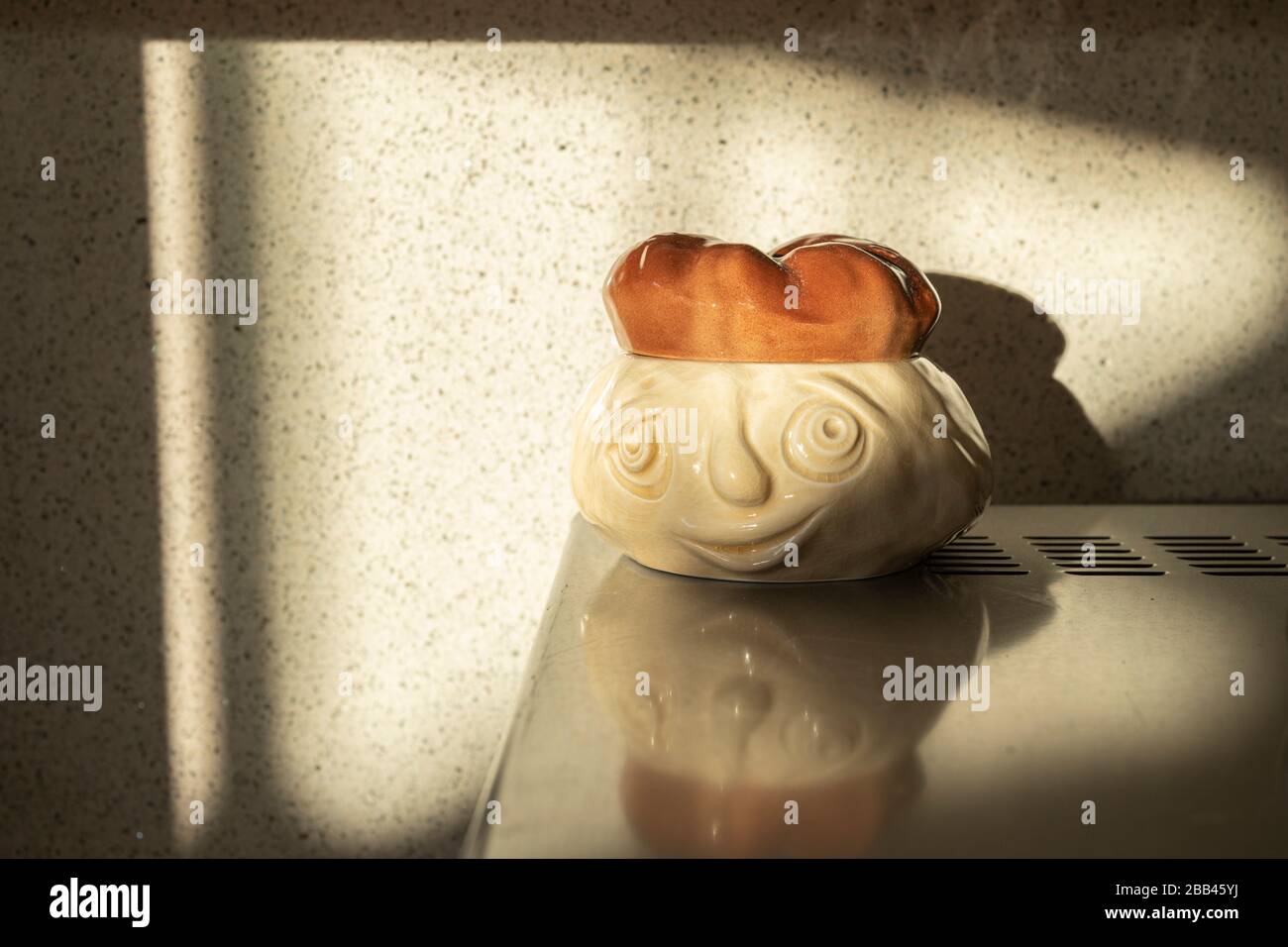 Letzte Sonnenstrahlen auf einem Sylvac-Brotsoße-Topf in der Küche, Stockfoto