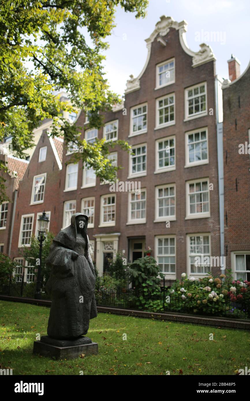 Statue einer Beguine Nonne im Innenhof des Begijnhofs, Amsterdam, Niederlande Stockfoto