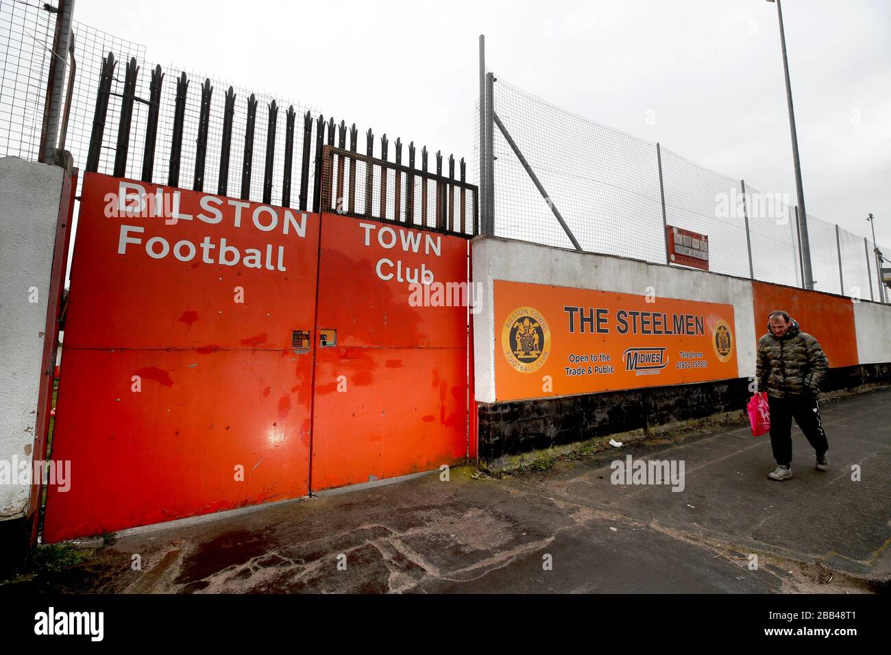 Ein Mann läuft am Bilston Town Football Club, West Midlands vorbei, der geschlossen bleibt, da Großbritannien weiterhin in Sperrstellung bleibt, um die Ausbreitung des Coronavirus einzudämmen. Stockfoto