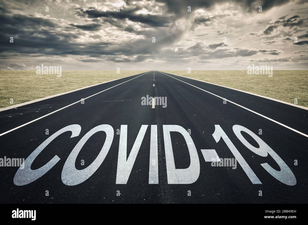 Covid-19 geschrieben auf einer Straße, dunkle Wolken, Coronavirus-Epidemie-Krisenkonzept Stockfoto