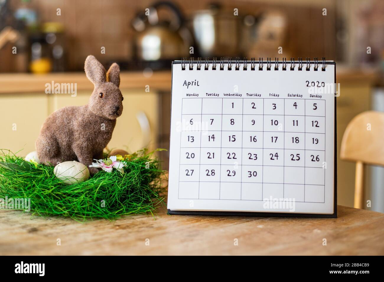 April 2020 Kalender und Osterbrötchen auf Holztisch in der Küche Stockfoto