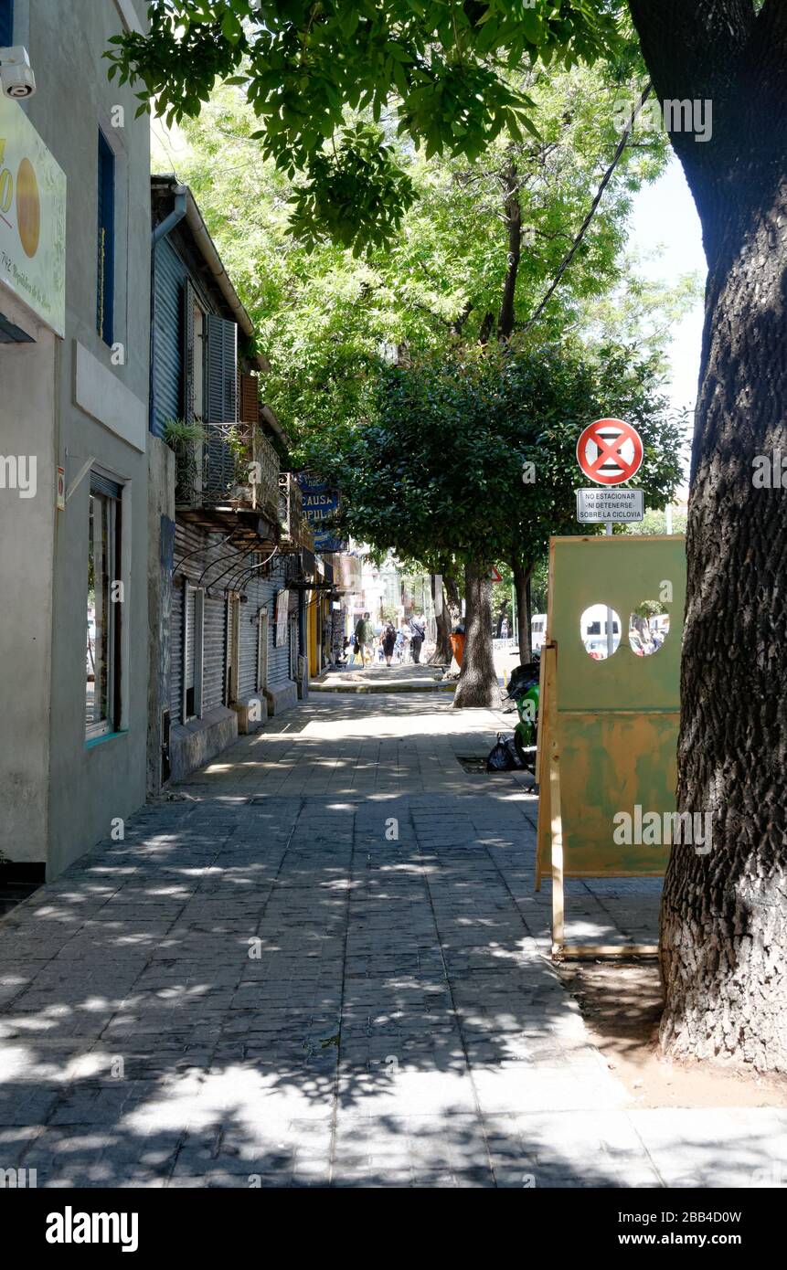 Von Bäumen gesäumte Straße in La Carminito, La Boca, Buenos Aires, Argentinien Stockfoto