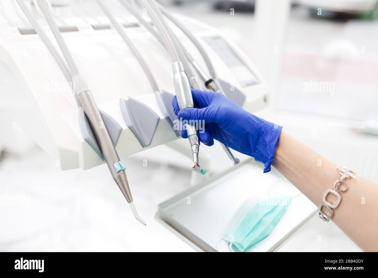 Die Hand des Zahnarztes nimmt eine der vielen Übungen. Zahnärztliche Ausrüstung Konzept Stockfoto