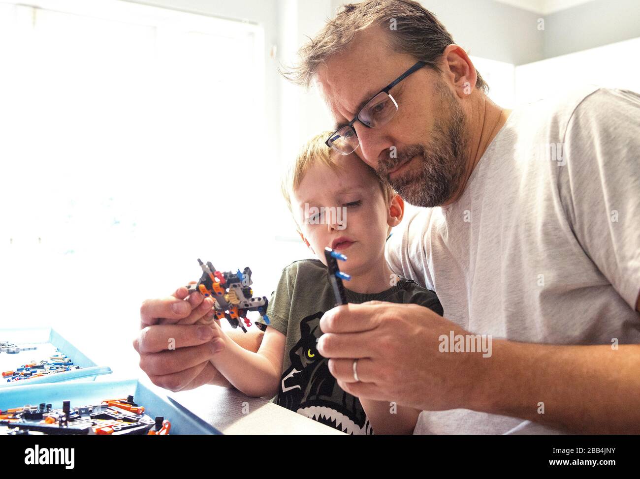 Jack baut mit seinem Papa etwas lego auf, zu Hause während seiner zweiten Woche der Schulschließungen aufgrund des Coronavirus. Stockfoto