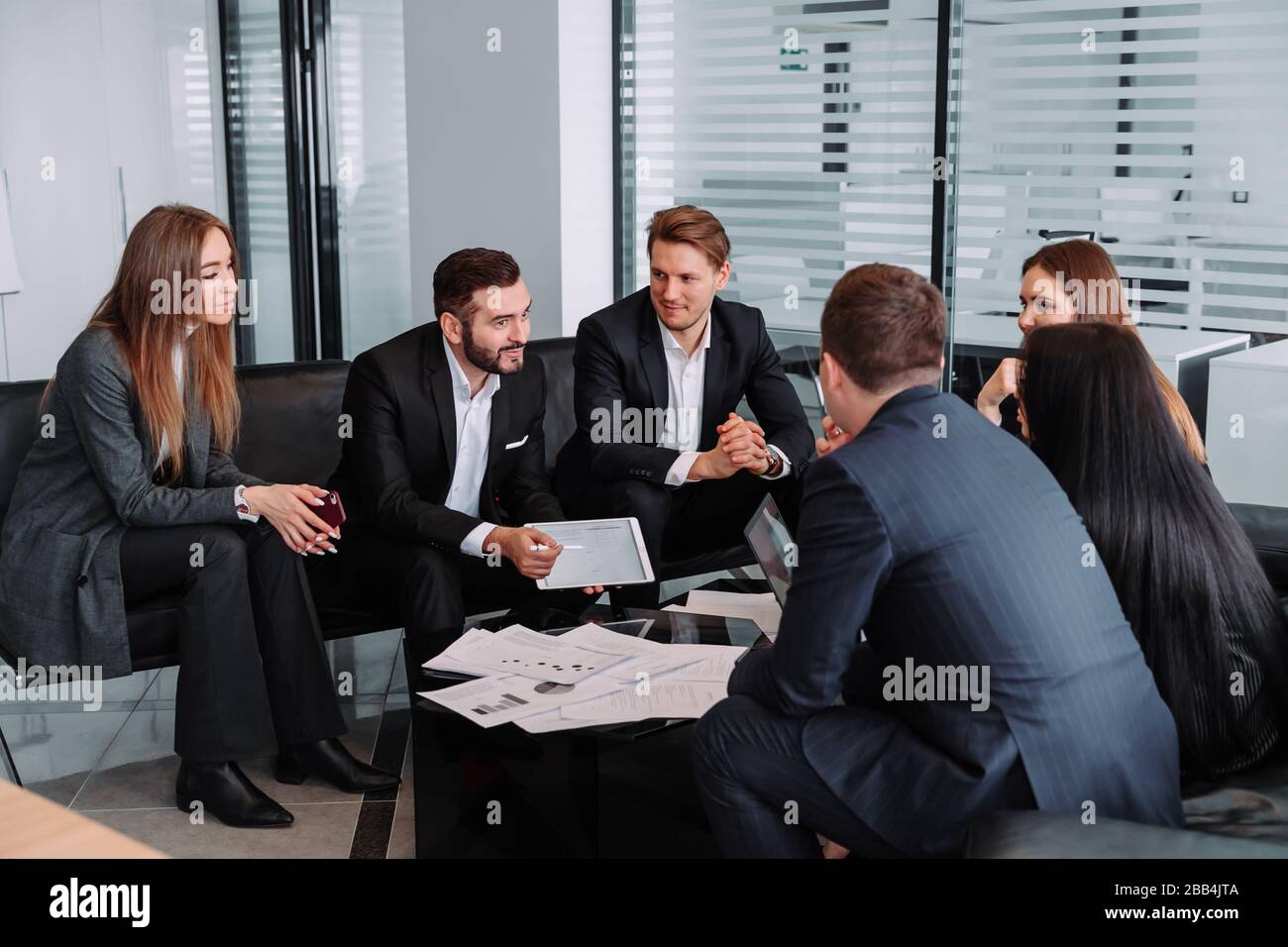 Treffen von Geschäftspartnern in einem modernen Büro, EINER Gruppe erfolgreicher Geschäftsleute. Diskussion eines wichtigen Unternehmensvertrages. Stockfoto