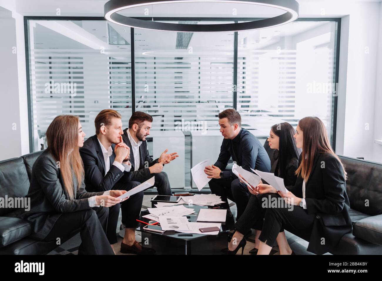 Treffen von Geschäftspartnern in einem modernen Büro, EINER Gruppe erfolgreicher Geschäftsleute. Diskussion eines wichtigen Unternehmensvertrages. Stockfoto