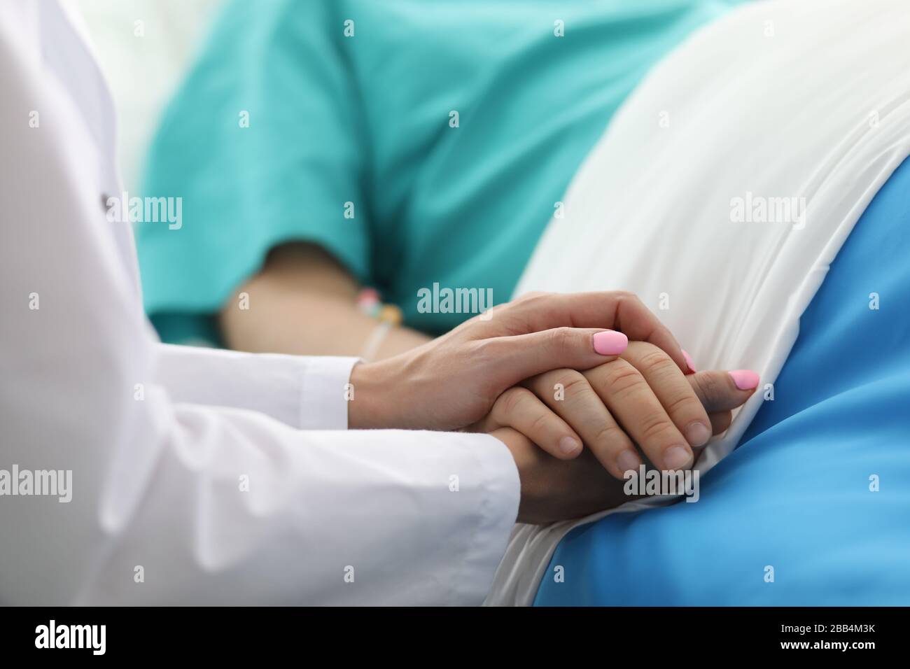 Die Ärztin hält den kranken Mann mit der Hand im Krankenhaus Stockfoto