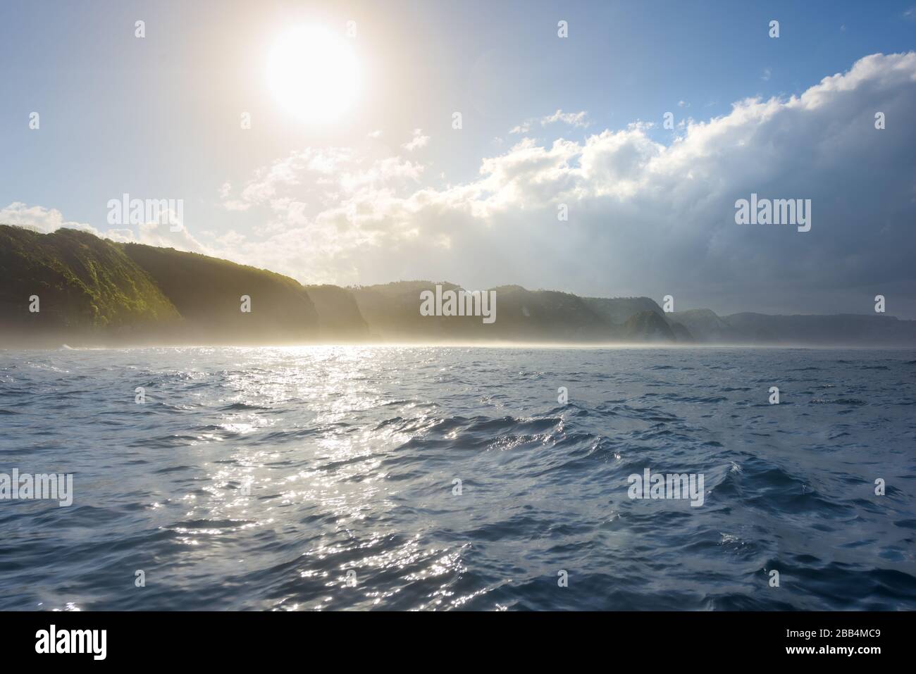 Südküste von Nusa Penida, mit Dschungelklippen und Wasserfällen, die im Meer ragen, bei Sonnenaufgang auf Bali, Indonesien Stockfoto