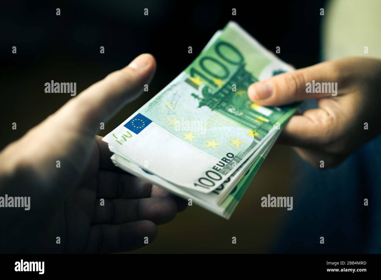 Nahaufnahme der Hand der Person, die Geld an die andere Hand gibt. Übertragung von Euro-Banknoten. Stockfoto