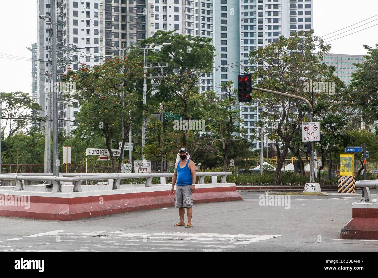 Quezon City. März 2020. Ein Bewohner, der eine Gesichtsmaske trägt, ist am 30. März 2020 an einer leeren Straße in Quezon City auf den Philippinen zu sehen. Credit: Rouelle Umali/Xinhua/Alamy Live News Stockfoto