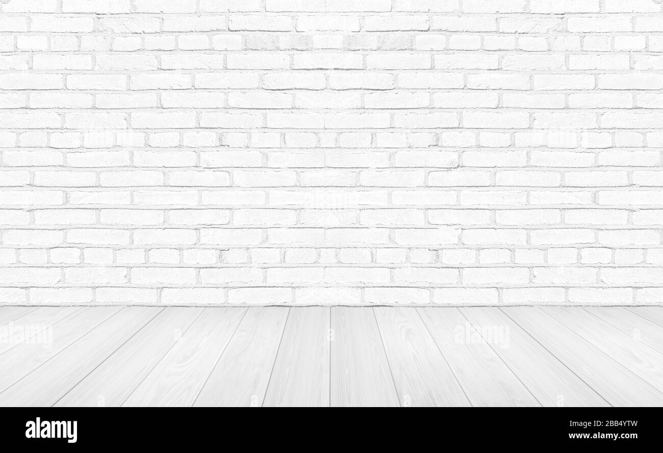 Weiße leere Holzböden mit Backstein-Wandhintergrund. Studio- oder Bürofläche. Stockfoto