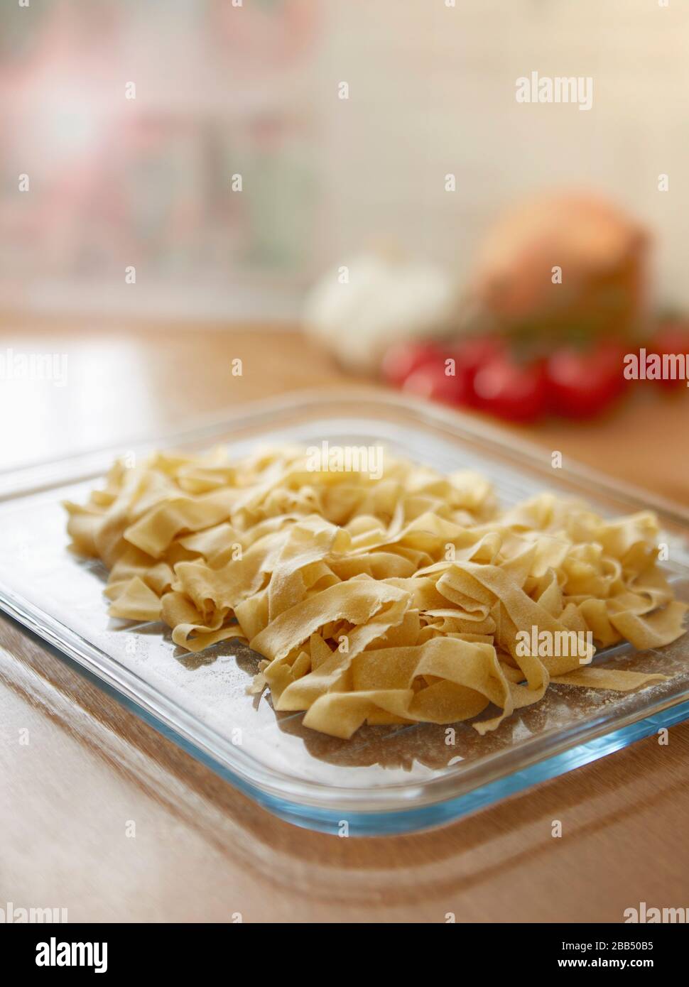 Hausgemachte frische Tagliatelle Pasta in der Küche auf Glastablett auf Küchenarbeitsoberfläche Stockfoto