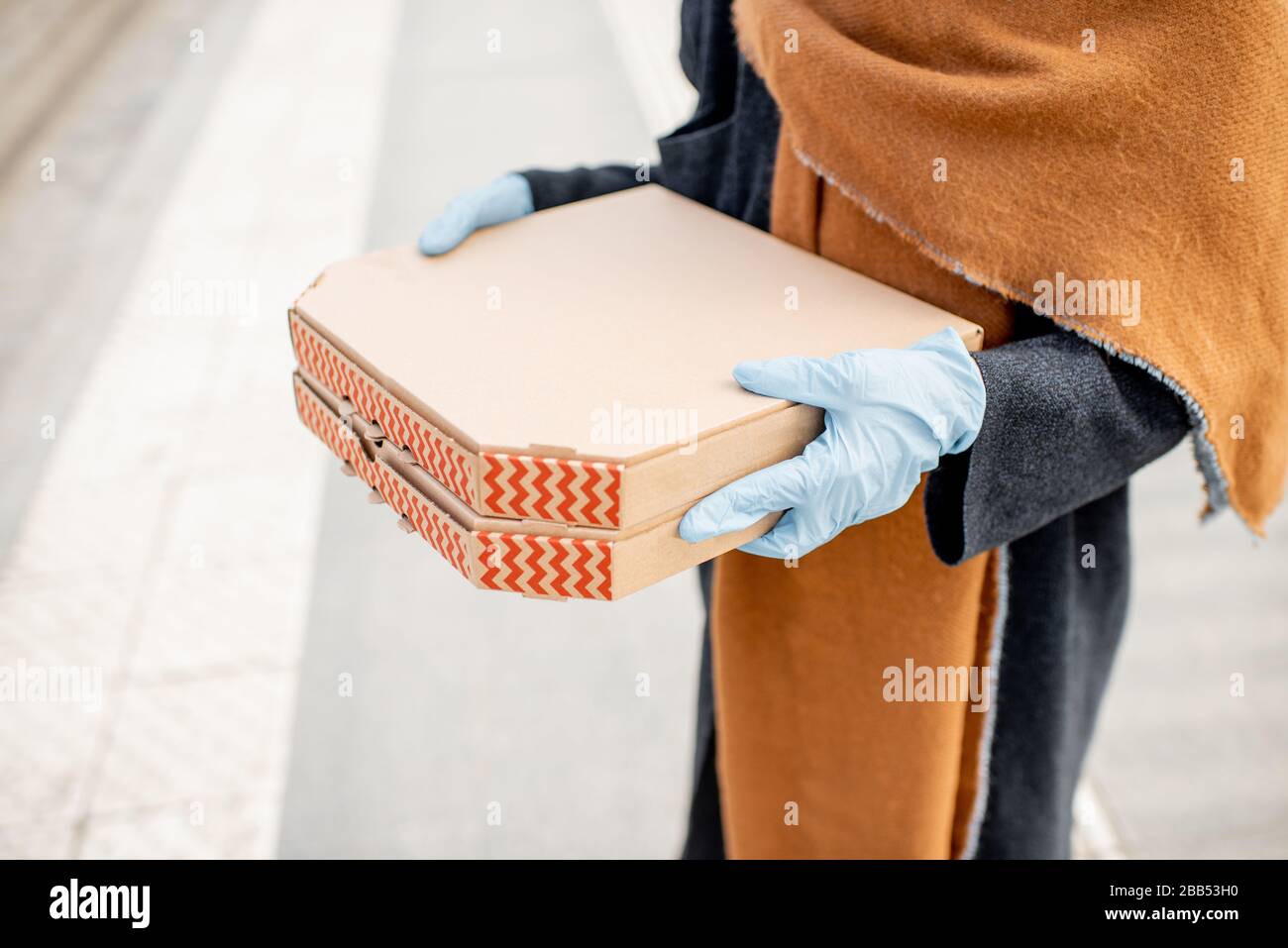 Pappe mit Pizza halten, während Sie während der Epidemie nach Essen gehen. Konzept der Mitnahme von Lebensmitteln während der Quarantäne Stockfoto