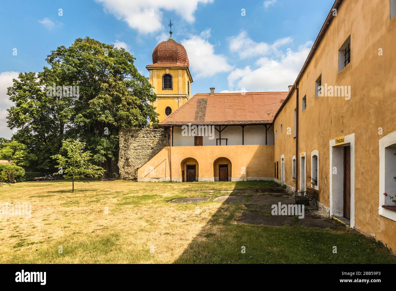 Panensky Tynec, Tschechische Republik - 15. Juli 2019: Gelb Glockenturm und ehemaliges Kloster der Klarissen, heute der Stadtverwaltung. Sonnigen Tag. Stockfoto