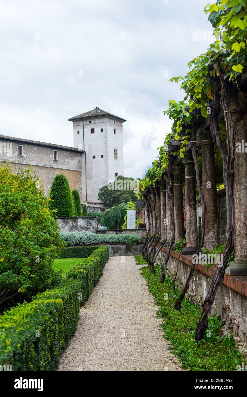Innenhof der historischen Burganlage in Trient, Italien. Im Hintergrund steht ein Turm, an den die Burgmauer grenzt. Auf der linken Seite können Sie se Stockfoto