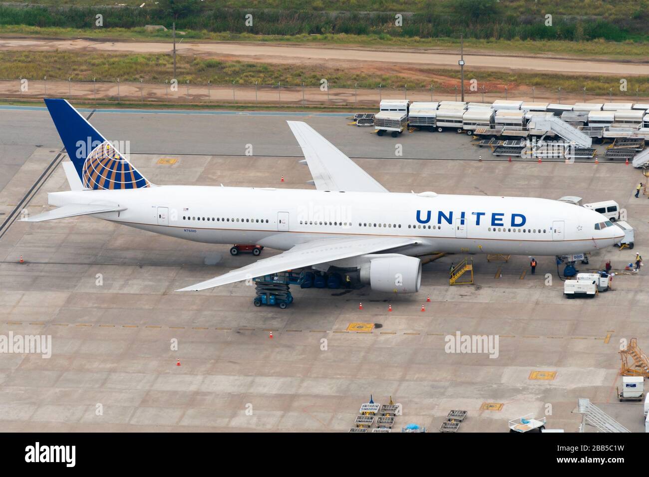 United Airlines Boeing 777 parkte auf einem abgelegenen Stand am Flughafen Guarulhos (GRU) Mechanische Arbeiten und Waschen zwischen langen Flügen. Luftansicht. Stockfoto