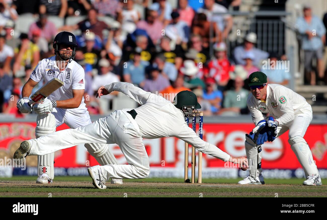 Englands Schlagmann Alastair Cook hat seinen Stopp durch den Tauchgang vom australischen Feldspieler Steve Smith, während des zweiten Tages des dritten Investec Ashes Testspiels im Old Trafford Cricket Ground Stockfoto