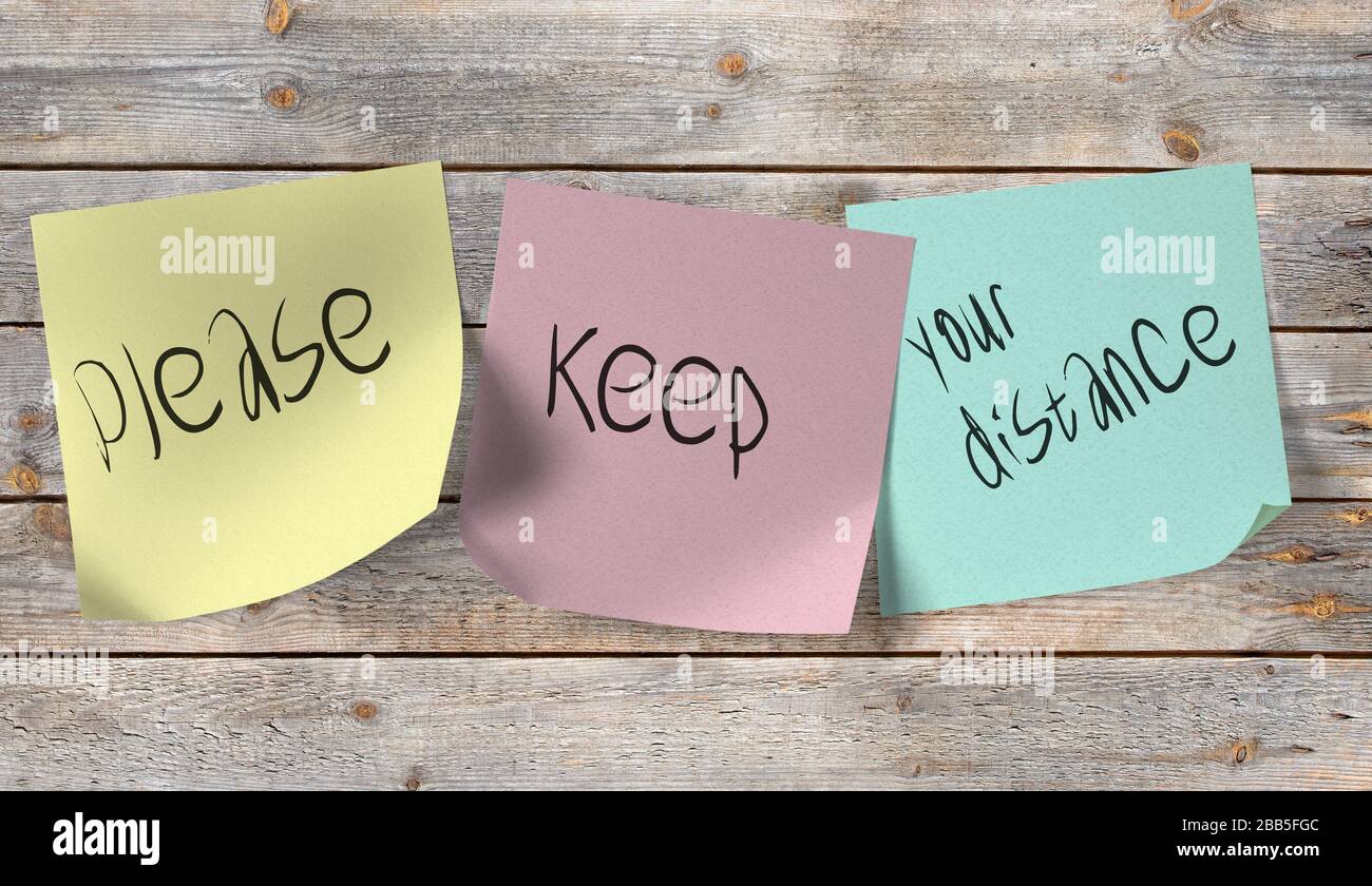 Hinweis mit der Aufschrift bitte Abstand auf einem Holzwalld halten Stockfoto