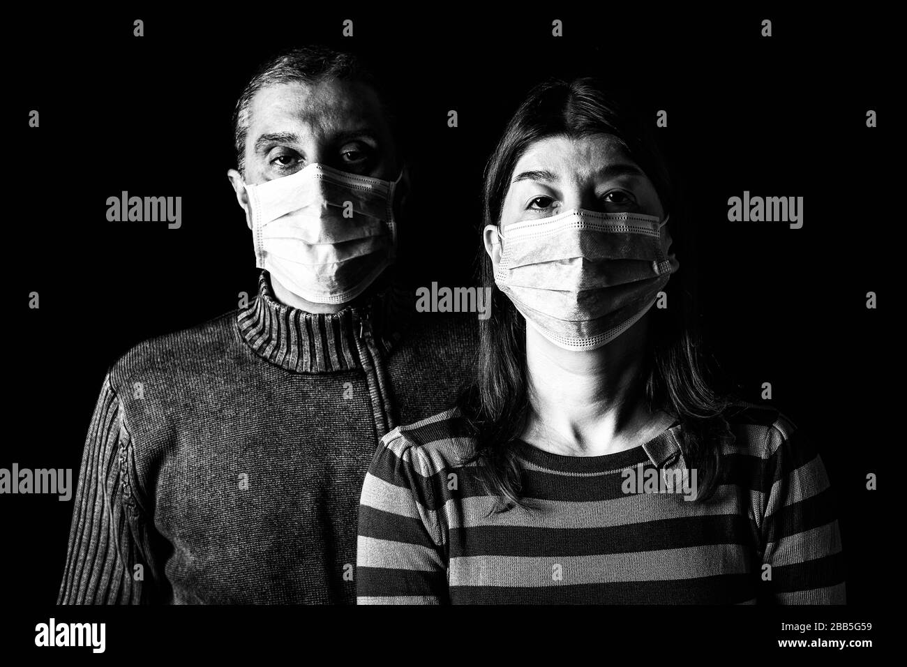 Mann und Frau mit chirurgischen Masken. Mit Gesichtsmaske geschützt koppeln. Pandemie oder Epidemie, erschreckend, Angst, Gefahrenkonzept. Schutz vor biologischer Gefährdung wie CO Stockfoto