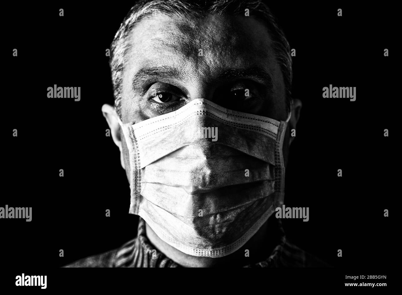 Mann mit chirurgischer Maske. Pandemie oder Epidemie und Schreckliches, Angst- oder Gefahrenkonzept. Schutz vor biologischer Gefährdung wie COVID-19 alias Coronavirus. Nahanschluss Stockfoto