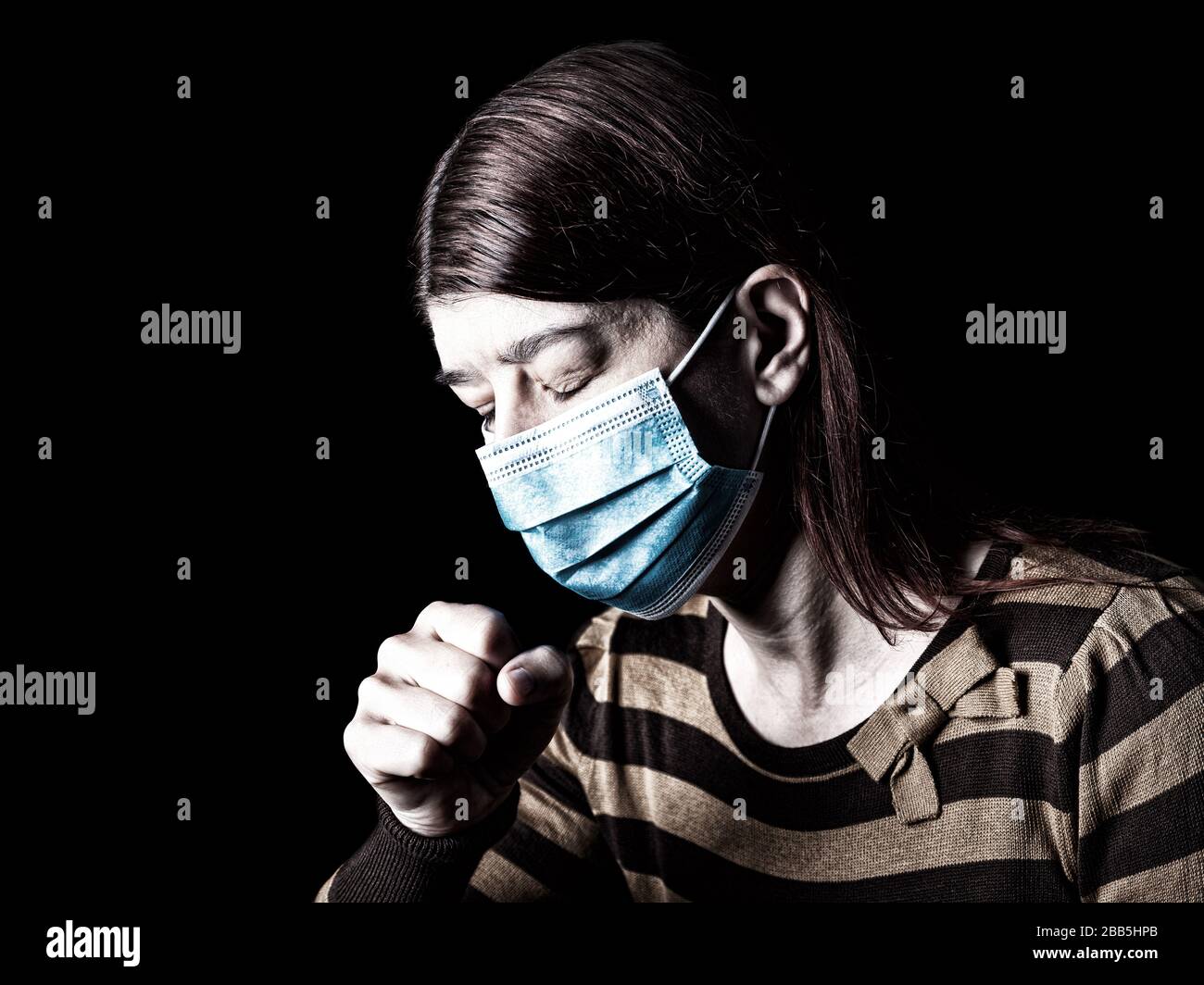 Frau mit chirurgischer Maske, die niest oder hustet. Pandemie oder Epidemie und Schreckliches, Angst- oder Gefahrenkonzept. Schutz gegen biologische Gefahren wie COVID-19 oder Coro Stockfoto