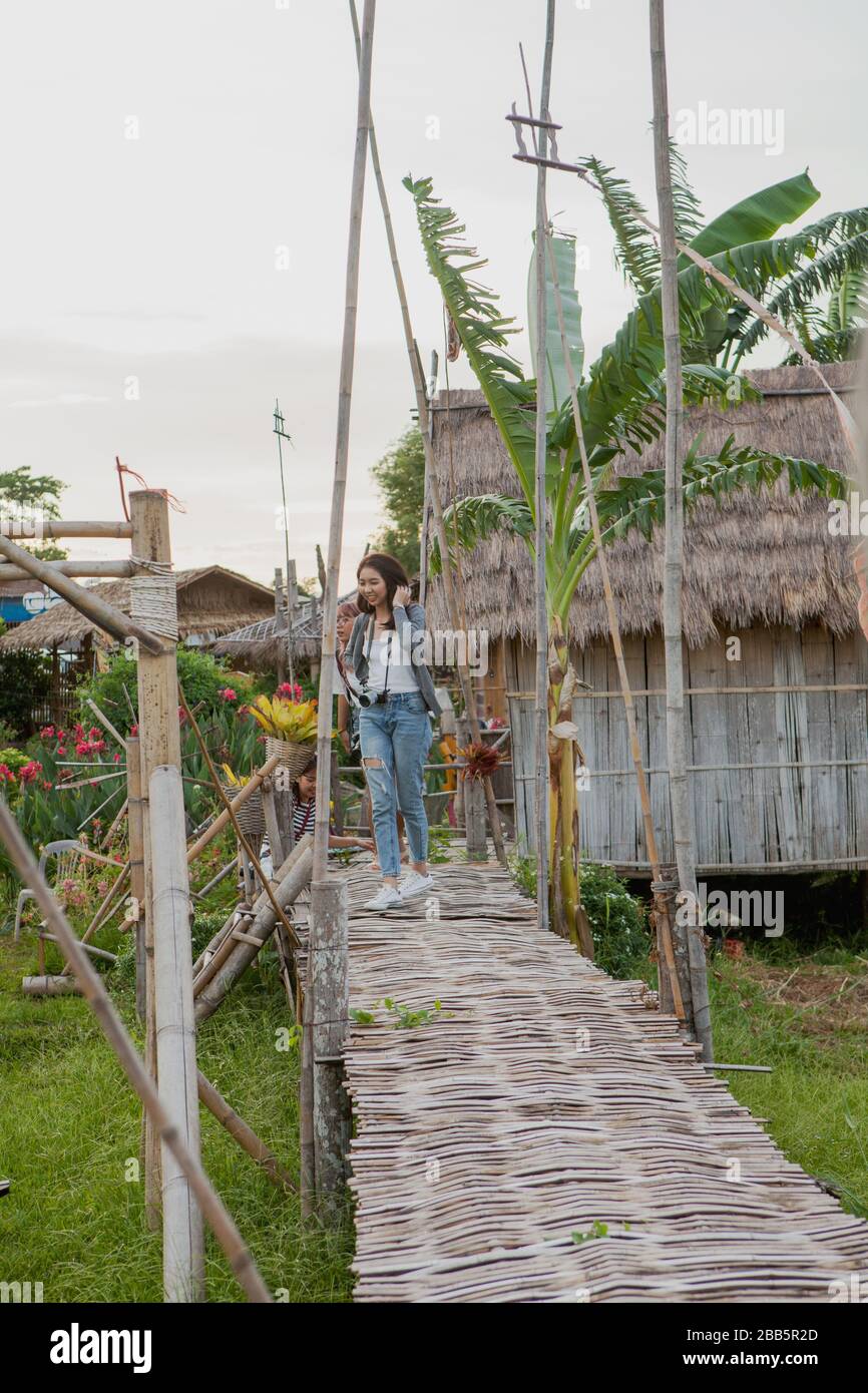 Unten in der Nachbarschaft des Wat Phuket befindet sich das Dorf Baan Ket. Mädchen laufen auf der Brücke. Stockfoto