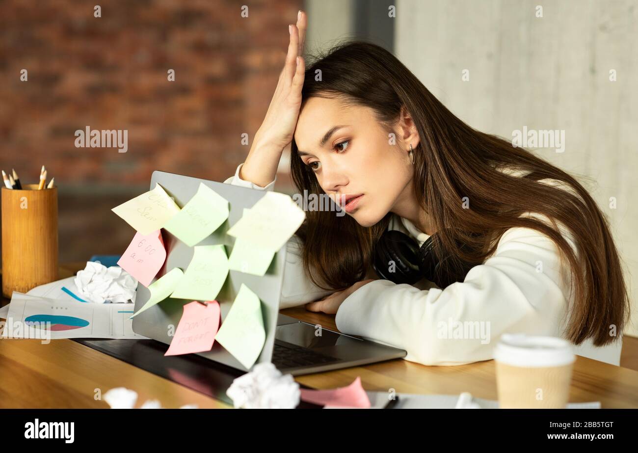 Viele Aufgaben und kein Ideenkonzept. Freiberufliches Mädchen sieht in Laptop Stockfoto
