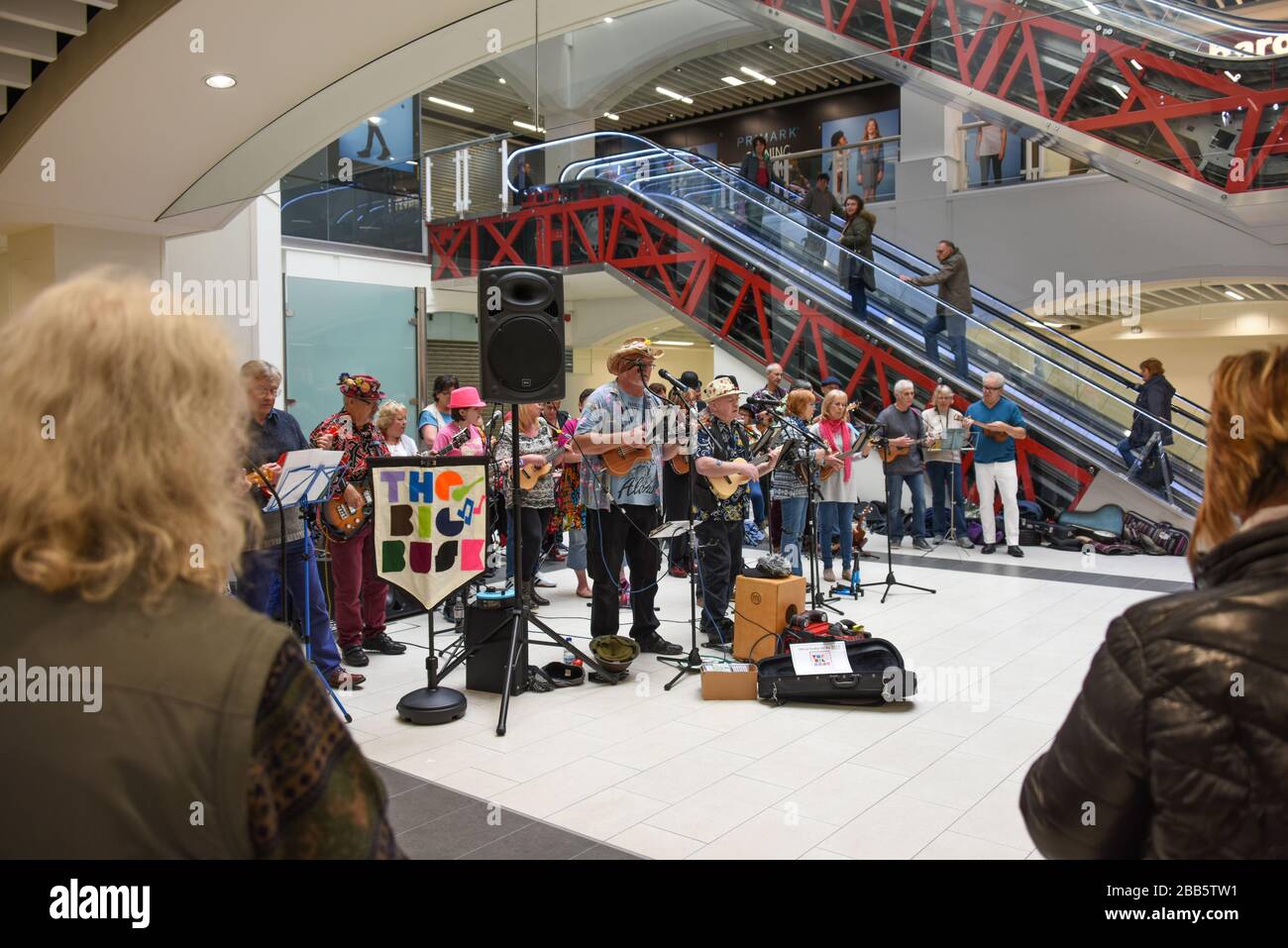 Eine große Gruppe von Musikern, die an einer Big Busk Veranstaltung in einem Einkaufszentrum in Shrewsbury, Großbritannien, mit Hilfe von Obdachlosen teilnehmen. Stockfoto