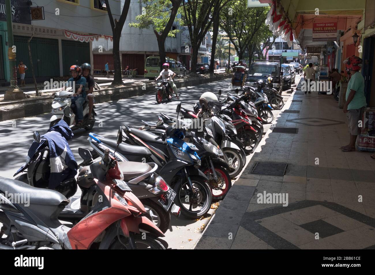 dh Asian Motorbikes City Street AMBON MALUKU INDONESIA Reihe von geparkten Transport Asian Motorbikes Motorräder Cityscooter südost asien Motorrad Stockfoto