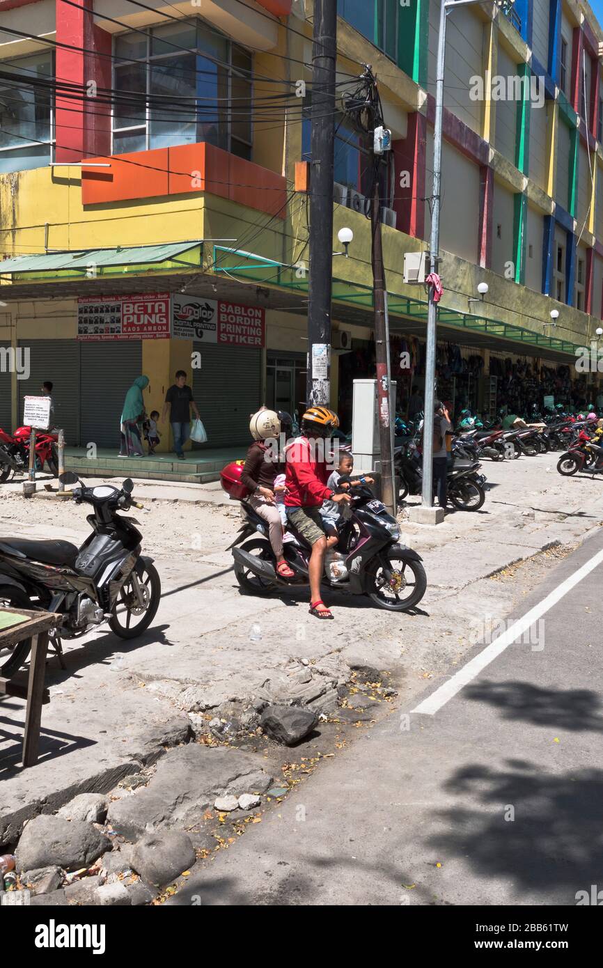 dh Indonesian Transport Motorrad AMBON MALUKU INDONESIA Familie auf Motorrad mit Helmen in der Stadt asiatischen Motorrad Menschen Kinder Stockfoto