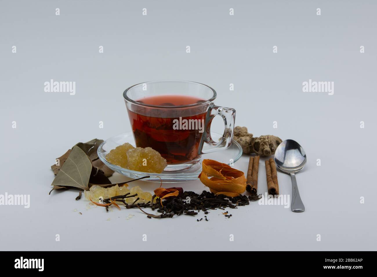 Nahaufnahme einer Tasse Kräutertee und verschiedener Kräuter auf weißem Hintergrund. Stockfoto